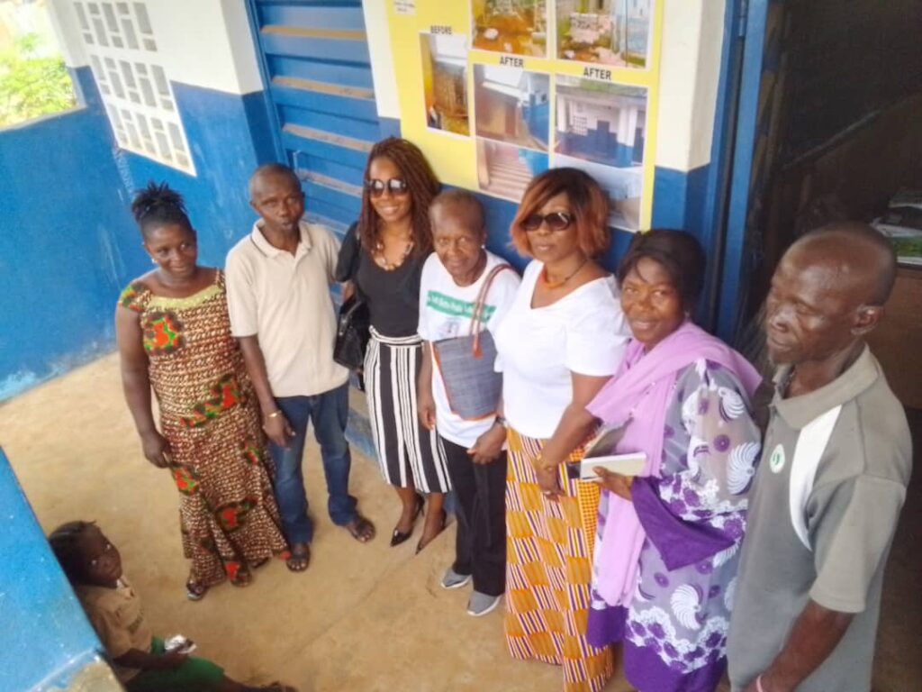 Isa and school staff outside the new classroom